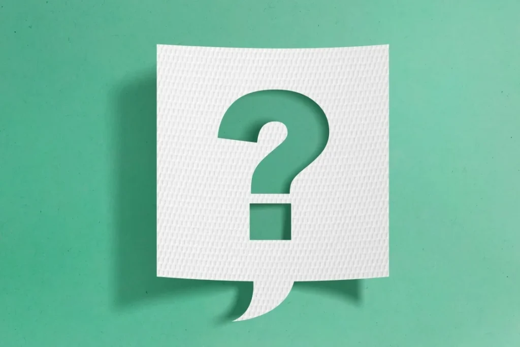 White textured sheet with a large green question mark on a green background, suggesting uncertainty or a question to answer.